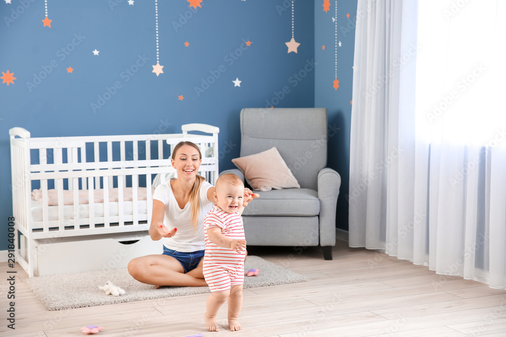 Mother teaching her little baby to walk at home