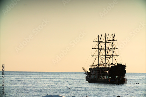 old pirate ship sailing at sea sunset