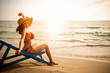 woman relax on chair beach in vacations with sunrise background.Enjoy asian women and the coconut at the beach with morning light background