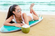 asian woman relax on surfboard beach in vacations.Beautiful woman relaxing with a drink coconut on a summer beach at a beautiful sea.