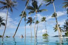 Woman Relaxing In Infinity Pool On Tropical Vacation