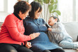 © MaaHoo Studio/Stocksy - Grandmother, pregnant daughter and grandson at home