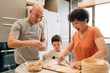 © MaaHoo Studio/Stocksy - Grandparents cooking with grandson