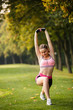 © Olga Mishyna - sport girl making exercises outdoors. Young sport woman in a park. Sport and fitness on open air. Exercise lunge leg on the grass and stretching