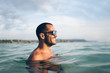 © Santi Nunez/Stocksy - Smiling man swimming in sea water