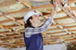© auremar - female builder working on wooden ceiling supports