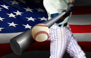 Baseball player hitting ball with American flag in background