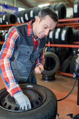 portrait of mechanic balancing wheel