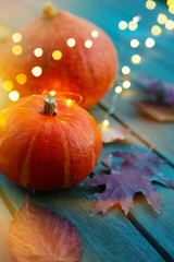 Wall Mural - Autumn pumpkin and holidays light decoration on wooden table; thanksgiving holiday party background,