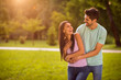 © deagreez - Portrait of cheerful couple laughing enjoying hugging piggyback wearing t-shirt denim jeans outdoors