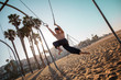© Llstock - A young man athlete working out on traveling rings on muscle beach, Santa Monica, California