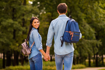 Poster - Behind view photo of cute pair groupmates walking dormitory hostel after lessons hold arms wear denim outfit