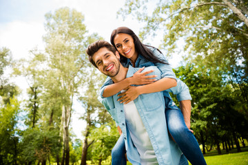 Wall Mural - Low angle view photo of cute pair rejoicing together walking summer green park outdoors wear denim outfit