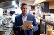 © Wavebreak Media - Restaurant manager using a tablet in a kitchen