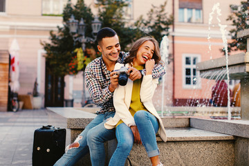 Happy young couple tourists making photos in the city