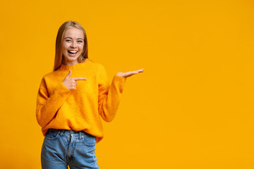 Cheerful teen girl demonstrate something on her empty palm