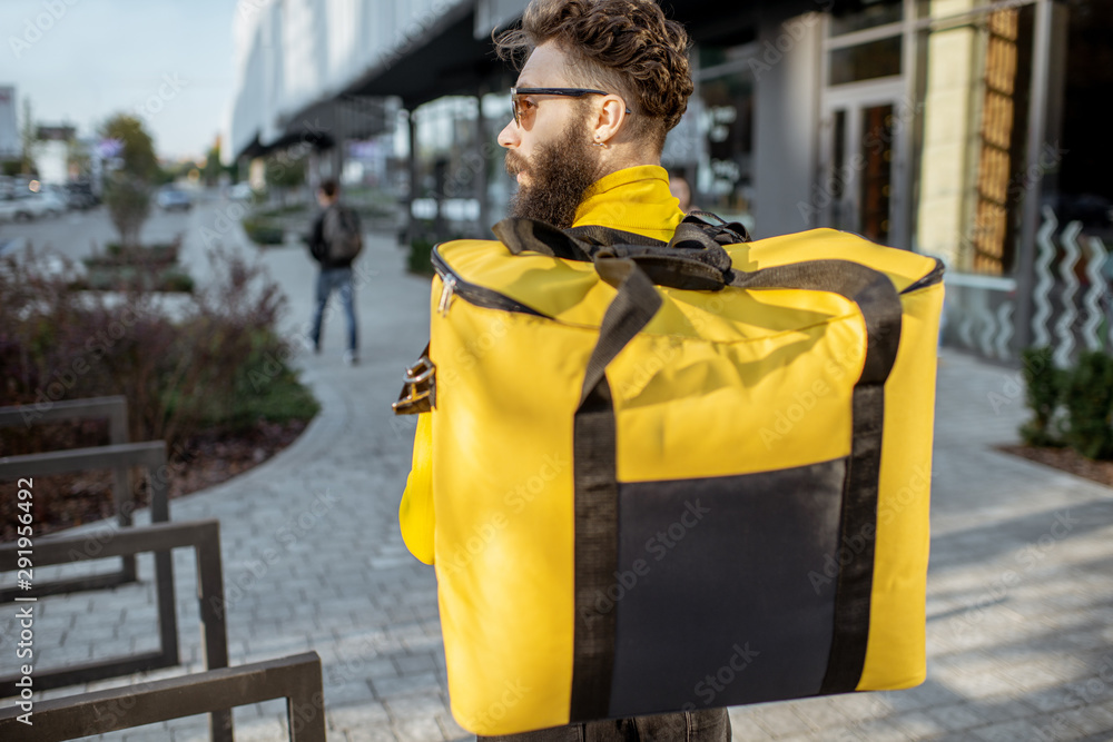 Delivery Man standing with yellow thermo backpack for food delivery ...