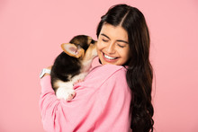 Cheerful Woman Holding Welsh Corgi Puppy, Isolated On Pink