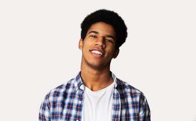 Wall Mural - Portrait of happy young african guy on white background