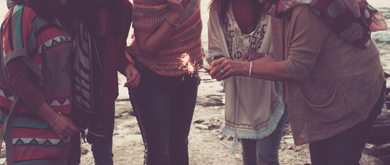 trendy boho fashion style and friendship celebration group of happy unrecognizable people with sparklers fire in outdoor leisure activity together -  love and friends alternative lifestyle