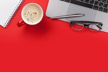 Office red workplace with coffee cup, supplies and computer
