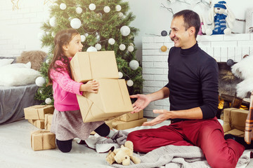 Wall Mural - Merry Christmas and Happy Holidays. Family preparation near the Xmas tree at home