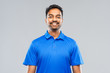 © Syda Productions - emotion, expression and people concept - smiling indian man in blue polo shirt over gray background
