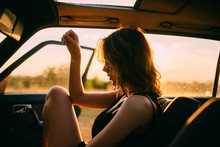 Side View Of Young Woman Sitting In Car