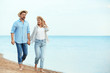 © New Africa - Happy romantic couple walking on beach, space for text
