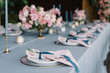 © Olga - Stylish and beautiful wedding table service with blue tablecloth, festive dishes and gentle pink napkins