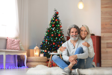 Wall Mural - Happy mature couple celebrating Christmas at home