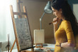 © StockPhotoPro - Artist working in the studio and looking at the painting