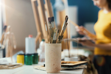 Creative woman painting on canvas in the studio