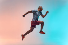 New Champion. Full Length Of Young African Man In Sports Clothing Jumping Against Colorful Background