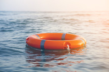 Orange Lifebuoy In Sea On Water. Life Ring Floating On Top Of Water. Life Ring In Ocean.Toning.