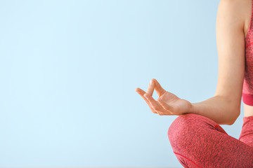 Wall Mural - Young woman meditating on color background