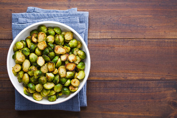 Wall Mural - Fresh homemade roasted Brussels sprouts in white bowl, photographed overhead with copy space on the right side