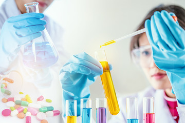 scientist with equipment and science experiments, laboratory glassware containing chemical liquid for research for pharmaceutical or analyzing a sample into test tube in laboratory