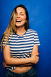 © ManuPadilla - Pretty smiling girl with blond hair, striped shirt with blue pants and blue background.