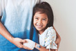 © pingpao - Sick asian child girl who have IV solution bandaged smiling and  hugging her mother with love in the hospital