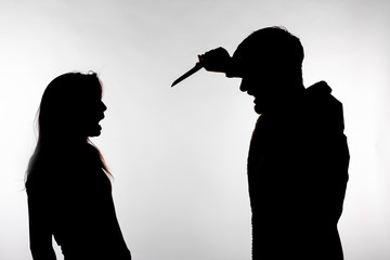 Aggression and abuse concept - man and woman expressing domestic violence in studio silhouette isolated on white background.