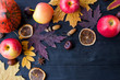 Autumn composition with copy space: yellow leaves, apples, pumpkin on a wooden table.