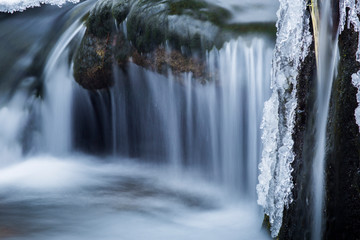 details of a frozen creek in heavy winter