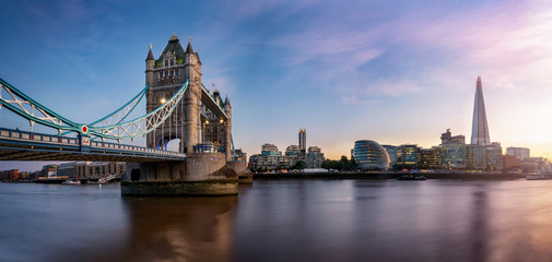 Fototapete - Die Tower Brücke in London mit der Skyline entlang der Themse bei Sonnenuntergang, Großbritannien