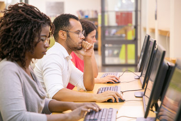 Wall Mural - multiracial group of students training in computer class. line of man and women in casual sitting at