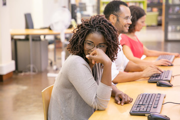 Wall Mural - mix raced trainees joking and laughing in computer class. row of man and women in casual sitting at 