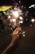 © Oleg Samoylov - Hand with Sparkler. blurry sparks and background