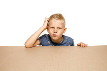 Cute And Upset Little Boy Opening The Biggest Postal Package. Disappointed Young Male Model On Top Of Cardboard Box Looking Inside. Gift, Present, Delivery, Shipment, Sales, Black Friday Concept.