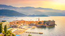 View Of The Old City Of Budva, Montenegro. A Sandy Beach Near The Walls Of The City (Richard The Head). Morning Mediterranean Landscape.