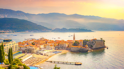 View of the old city of Budva, Montenegro. A sandy beach near the walls of the city (Richard the Head). Morning Mediterranean landscape.